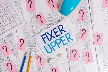 Writing note showing Fixer Upper. Business concept for house in need of repairs used chiefly connection with purchase Writing tools and scribbled paper on top of the wooden table