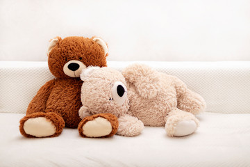 Children's toys - bears of brown and beige color are sitting on the sofa.
