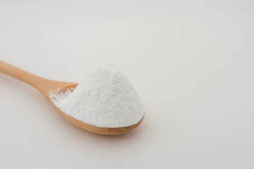 Close-up of tapioca starch or flour powder in wooden spoon with white background isolated