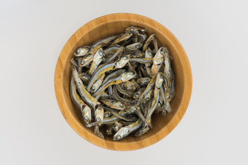 Dried anchovies used in Asian cuisine in glass bowl white background isolated