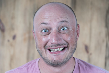 Portrait of middle-aged caucasian bald man looking straight at camera, close up