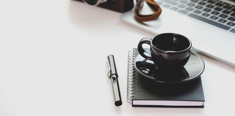 Trendy workplace with black coffee cup and laptop computer with copy space