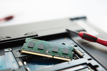Close-up view of technician open a cover and upgrade a notebook by add a new ram and remove old ram