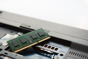 Close-up view of technician open a cover and upgrade a notebook by add a new ram and remove old ram