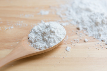 Fototapeta na wymiar Close-up of tapioca starch or flour powder in wooden spoon with wooden background