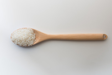 Top view of Japanese rice in wooden spoon white background isolate