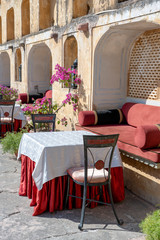 Street cafe in old town, outside in Jaipur, Rajasthan, India. Table, sofa and chairs near old wall