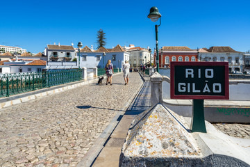 View Roman Bridge (Puente Romano) in Tavira, a pedestrian bridge crossing the Gilao River, Algarve, Portugal