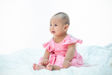 Sad baby on a white bed