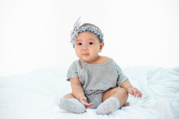 Babies are sad on a white bed.