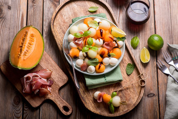 Melon, mozzarella, prosciutto appetizer or snack, summer salad with cantaloupe melon - obrazy, fototapety, plakaty