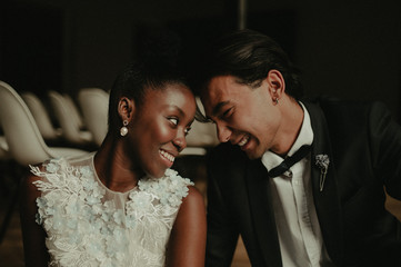 Bride and groom hug each other. Interracial marriage. Asian bride and groom.