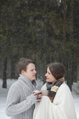 pair of lovers on a date winter afternoon in a snow blizzard