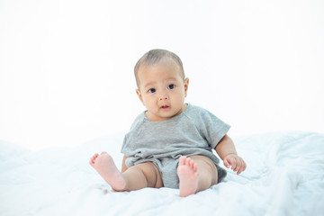 The little boy sitting on the bed