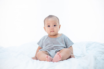 The little boy sitting on the bed
