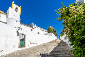 Steep cobbled street in Tavira old town leading to Tavira Castle and St. Mary's Church, Algarve, Portugal