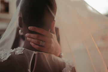 bride and groom covered with veil close-up. Interracial marriage. Asian bride and groom.