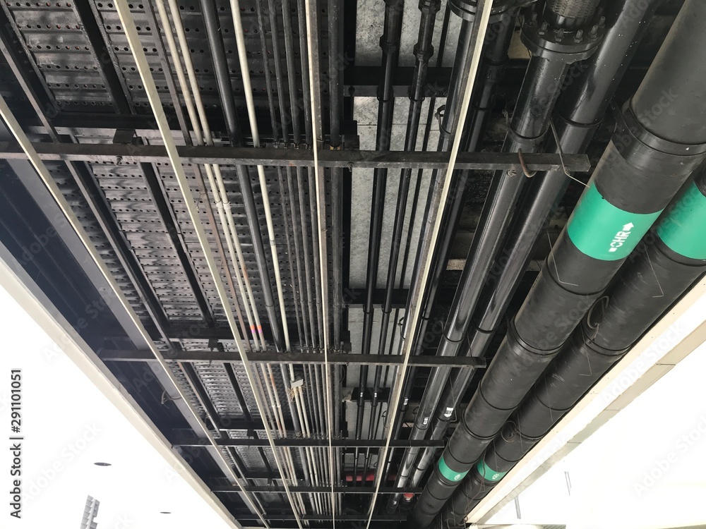 Poster underground car park service pipings running along the ceiling at a petroleum and gas refining indus