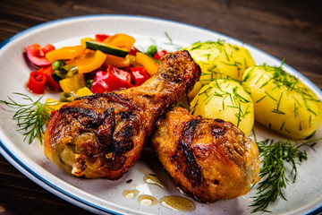 Grilled chicken drumsticks with boiled potatoes and vegetables