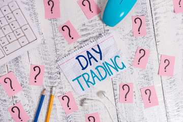 Writing note showing Day Trading. Business concept for securities specifically buying and selling financial instruments Writing tools and scribbled paper on top of the wooden table