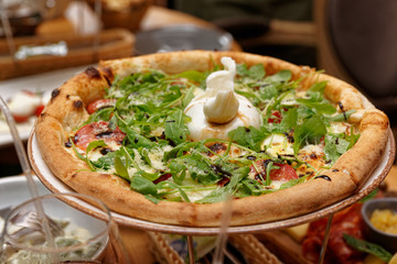 Pizza with rocket salad and burrata cheese