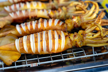 Grilled squids for sell at street food market in island Koh Phangan, Thailand . Thai cuisine, closeup