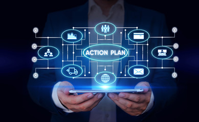 Writing note showing Action Plan. Business concept for list of things or schedule to be made thia current year Male wear formal suit presenting presentation smart device