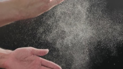Slow motion closeup man clapping hands with fine powder