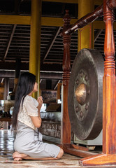 Fototapeta na wymiar Asian woman touching big gong
