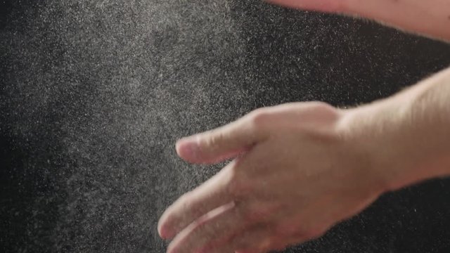 Slow motion closeup man clapping hands with fine powder