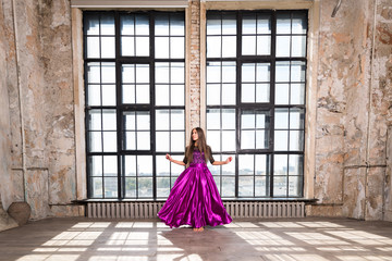 Young happy cheerful woman with long hair, posing in the interior with large Windows. Indoor...