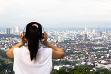 The young woman listened to the music in relaxation with a beautiful view.