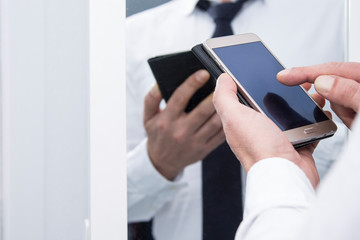 businessman using mobile phone in front of the mirror