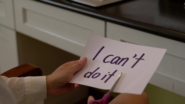 Hands using scissors to remove the word I can't do it to I can do it concept for self belief, positive attitude and motivation