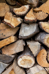 A pile of cut firewood abstract texture. Lots of stacked wooden logs piling, tightly alligned. Wallpaper, background, repetitive pattern. Lumber, timber concept. Horizontal shot, wall of wood