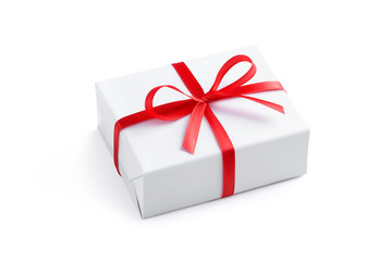 Side view of a festive rectangular gift box wrapped in white paper and tied with a red satin ribbon with a bow isolated on white background