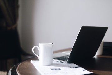 laptop and cup of coffee on table