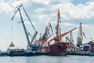 Port cranes and equipment for loading and unloading cargo. The concept of transportation of goods by water.