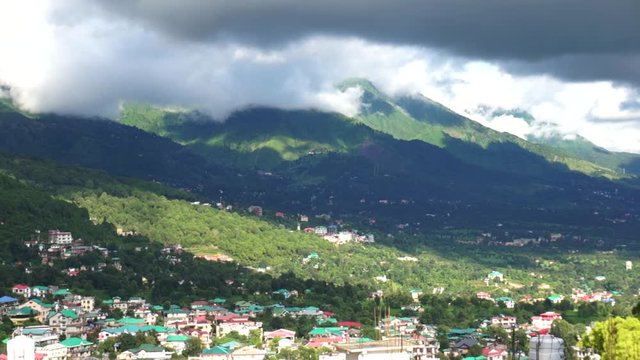 Aerial cityscape shot of the hill station of dharamshala, mcleodganj, shimla showing the beautiful houses, lush mountains and clouds