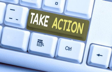 Conceptual hand writing showing Take Action. Concept meaning Supporting what you say not just words but through evidence White pc keyboard with note paper above the white background
