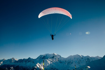 Paraglider silhouette in French Alps.