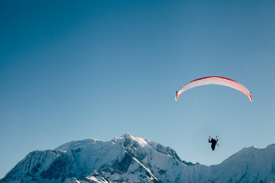 Paraglider silhouette in French Alps.