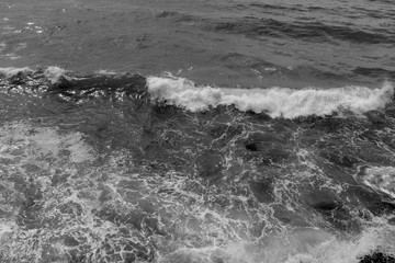 black and white sea with a white foamy wave