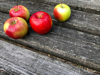 Four apples on the table. Photo background with apples with copy space. Red apples on a wooden background