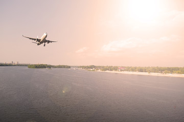 Fototapeta na wymiar Airliner over the river in the sky. The sun shines.