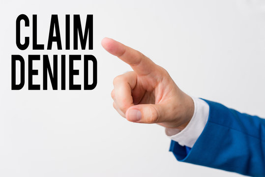 Writing note showing Claim Denied. Business concept for Requested reimbursement payment for bill has been refused Isolated hand pointing with finger. Business concept pointing finger