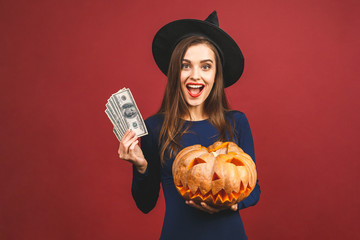 October sale! Halloween Witch with a carved Pumpkin and money - isolated on red background....