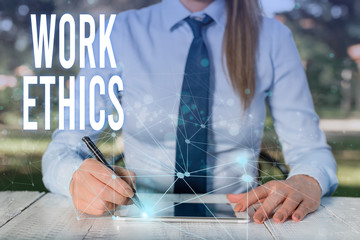 Conceptual hand writing showing Work Ethics. Concept meaning A set of values centered on the importance of doing work Female human wear formal work suit presenting smart device