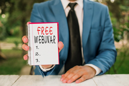 Text sign showing Free Webinar. Business photo text Lecture Workshop Seminar that is transmitted over the Web Man holds empty paper with copy space in front of him