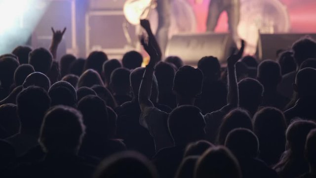Crowd of fans are cheering at open-air rock concert